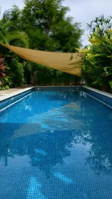 a hammock is hanging over a swimming pool at Apartment with large terrace and garden view in Uvita
