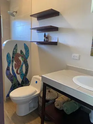 a bathroom with a toilet and a sink at Apartment with large terrace and garden view in Uvita