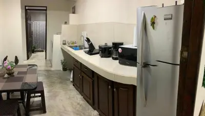 a kitchen with a white refrigerator and a table at La Fortuna Raft House in Fortuna