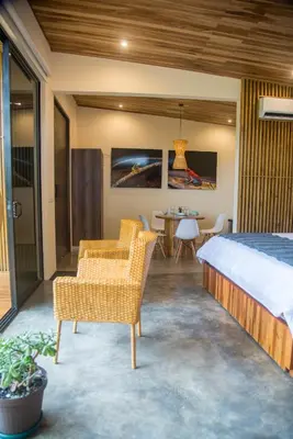 a bedroom with a bed and two chairs and a table at Scenic Volcano Villas with Hot Tub in Fortuna