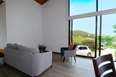 a living room with a white couch and a chair at Nambí Monteverde in Monteverde Costa Rica