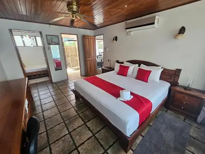 a bedroom with a large bed with a red blanket at Villa Tucán - La Fortuna in Fortuna