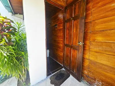 an entrance to a wooden wall with a wooden door at Villa Tucán - La Fortuna in Fortuna
