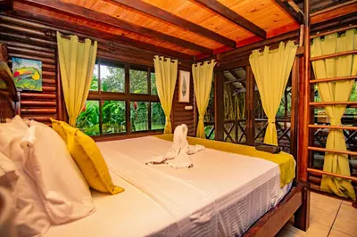 a bedroom with a bed with an animal on it at Cabaña Los Tucanes in Fortuna