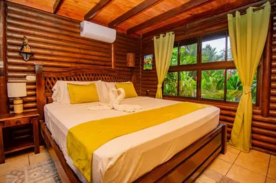 a bedroom with a bed in a log cabin at Cabaña Los Tucanes in Fortuna