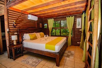 a bedroom with a bed in a log cabin at Cabaña Los Tucanes in Fortuna