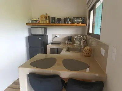 a kitchen with a table and a sink and a refrigerator at Villa deluxe, jacuzzi, cocina in Fortuna
