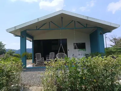 a small house with chairs and a porch at Villa deluxe, jacuzzi, cocina in Fortuna