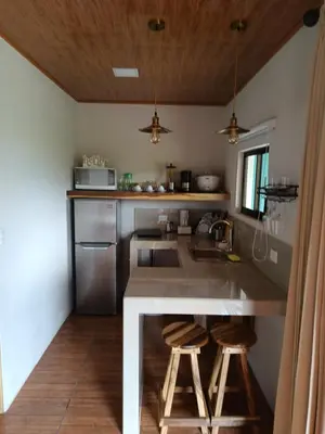 a kitchen with a sink and a counter with stools at Villa deluxe, jacuzzi, cocina in Fortuna