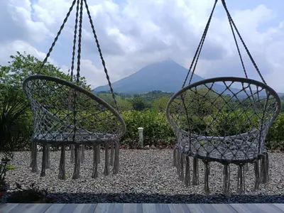 two chairs hanging from chains with a mountain in the background at Villa deluxe, jacuzzi, cocina in Fortuna