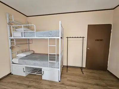 a room with two bunk beds and a door at Hostel La Cali Inn in San José