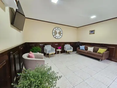 a lobby with couches and chairs and a flat screen tv at Hostel La Cali Inn in San José