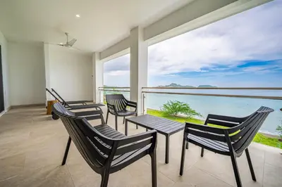a room with chairs and a table with a view of the ocean at Golden Palms#10 in Playa Flamingo