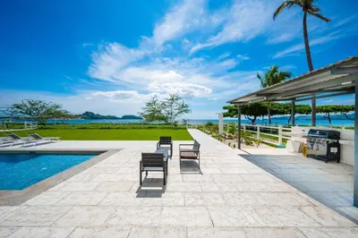an outdoor patio with chairs and a swimming pool at Golden Palms#10 in Playa Flamingo