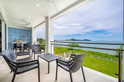 a balcony with chairs and a view of the ocean at Golden Palms#10 in Playa Flamingo