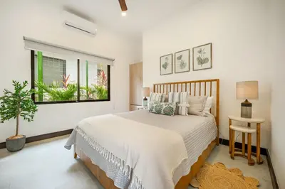 a bedroom with a large bed and a window at Villa Juntos in Tamarindo