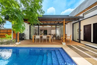a house with a swimming pool and a dining area at Villa Juntos in Tamarindo