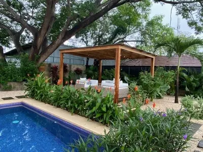 a gazebo and a swimming pool in a garden at Villa Juntos in Tamarindo