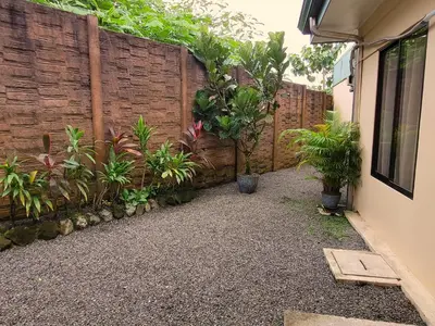 a backyard with a wooden fence and plants at Arenal Honey House in Fortuna