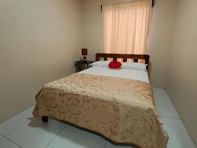 a bedroom with a bed with a red rose on it at Arenal Honey House in Fortuna