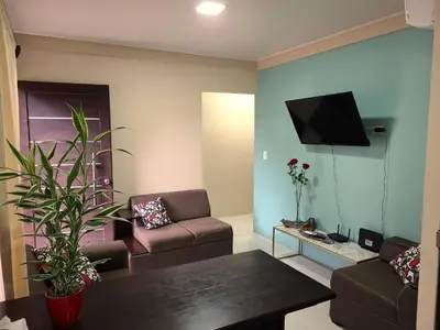 a living room with a couch and a tv at Arenal Honey House in Fortuna