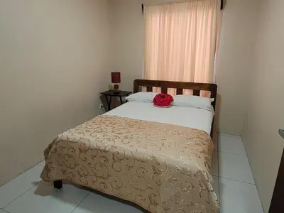 a bedroom with a bed with a red rose on it at Arenal Honey House in Fortuna