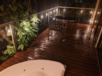 a bath tub sitting on a wooden deck with a table at Charmin forest cabin in Fortuna