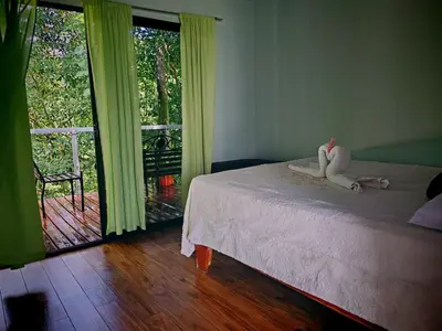 a bedroom with a bed and a large window at Charmin forest cabin in Fortuna