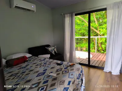 a bedroom with a bed and a sliding glass door at Charmin forest cabin in Fortuna