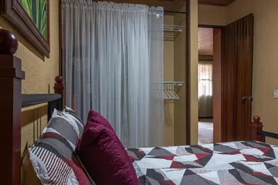 a bedroom with a bed with a quilt on it at Cozy 3 Bedroom House 5mins from the Airport in Alajuela City