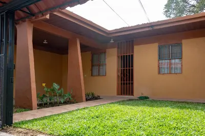 a house with a glass roof and a yard at Cozy 3 Bedroom House 5mins from the Airport in Alajuela City