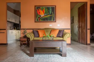 a living room with a couch and a coffee table at Cozy 3 Bedroom House 5mins from the Airport in Alajuela City