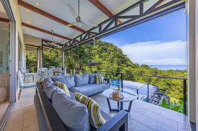 a living room with a couch and a table at Ocean View Villa With Pool and Spectacular Sunsets in Ballena