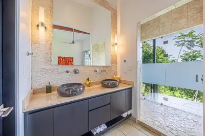 a bathroom with two sinks and a large window at Ocean View Villa With Pool and Spectacular Sunsets in Ballena