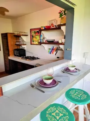 a kitchen with two stools and plates on a counter at Casa Macondo 3 bdrm w private pool, close to beach, Esterillos Oeste in Esterillos Este