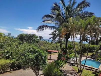 a resort with a swimming pool and palm trees at Casa Macondo 3 bdrm w private pool, close to beach, Esterillos Oeste in Esterillos Este