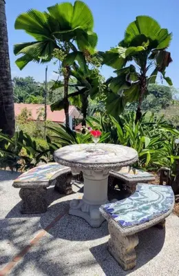 a table and two benches and a table with a flower on it at Casa Macondo 3 bdrm w private pool, close to beach, Esterillos Oeste in Esterillos Este