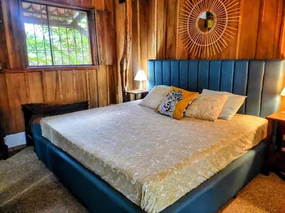a bedroom with a blue bed with a window at Casa Macondo 3 bdrm w private pool, close to beach, Esterillos Oeste in Esterillos Este