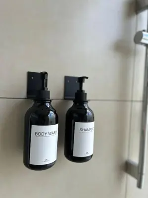 two bottles of soap sitting on a shelf in a bathroom at Villa Luxury Volcano Paradise Retreat in Fortuna