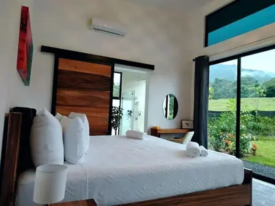 a bedroom with a large bed with a large window at Villa Luxury Volcano Paradise Retreat in Fortuna