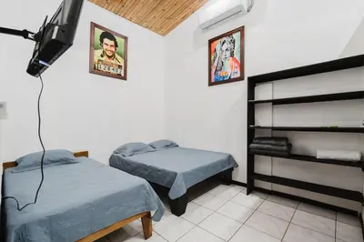 a room with two beds and a television in it at Apartamento Frigia 2 in Quepos