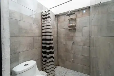 a bathroom with a toilet and a shower at Apartamento Frigia 2 in Quepos