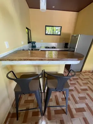a kitchen with a large island with two chairs under it at Villas Casa Paz in Cóbano