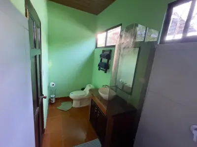 a bathroom with a toilet and a sink and a mirror at Villas Casa Paz in Cóbano