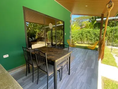 a dining room with green walls and a table and chairs at Villas Casa Paz in Cóbano
