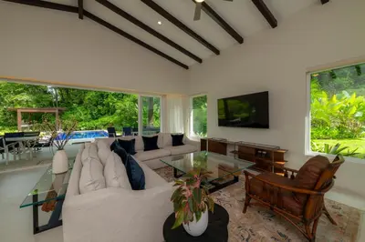 a living room with a couch and a table at Casa Forest 4 bdrs private pool in Los Suenos in Herradura