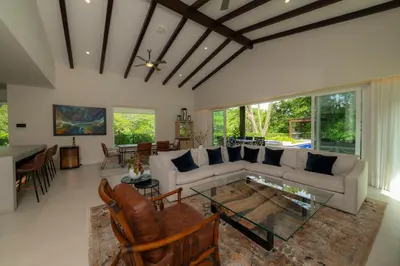 a living room with a couch and a table at Casa Forest 4 bdrs private pool in Los Suenos in Herradura