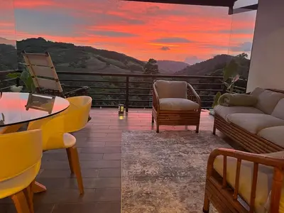 a living room with a view of a sunset at Yaloco House Monteverde in Monteverde Costa Rica