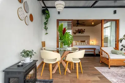 a living room with a table and chairs and a bedroom at Yaloco House Monteverde in Monteverde Costa Rica