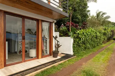 a house with sliding glass doors and a porch at Yaloco House Monteverde in Monteverde Costa Rica